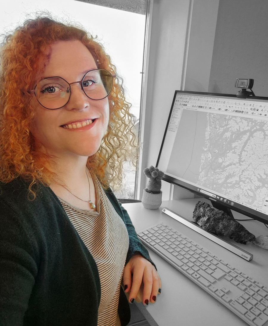 Portrett av Alexandra Ania Fjellvik ved en arbeidsstasjon med GIS-kart